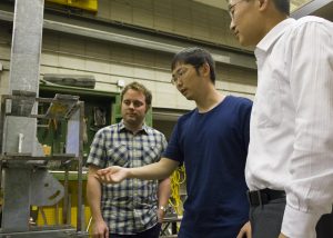 Hao Wu (center) demonstrates the TLWD theory