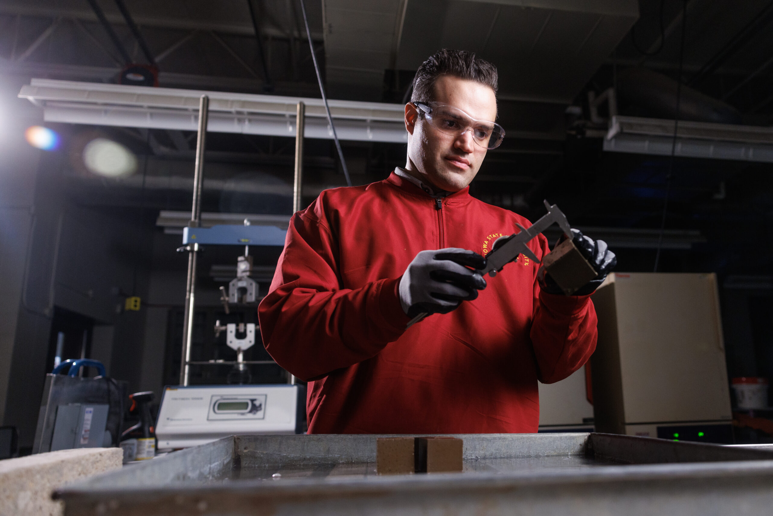 Saeed B. Nia testing and measuring concrete samples.