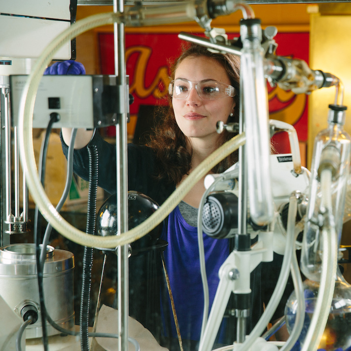 A student works with equipment in a lab with lots of tubing.